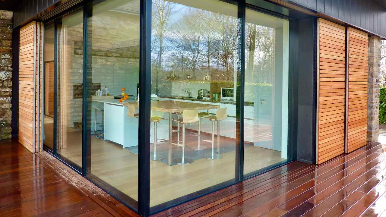 Extension d'une cuisine avec ouverture absolument totale sur le jardin avec baies coulissantes à galandage d'angle