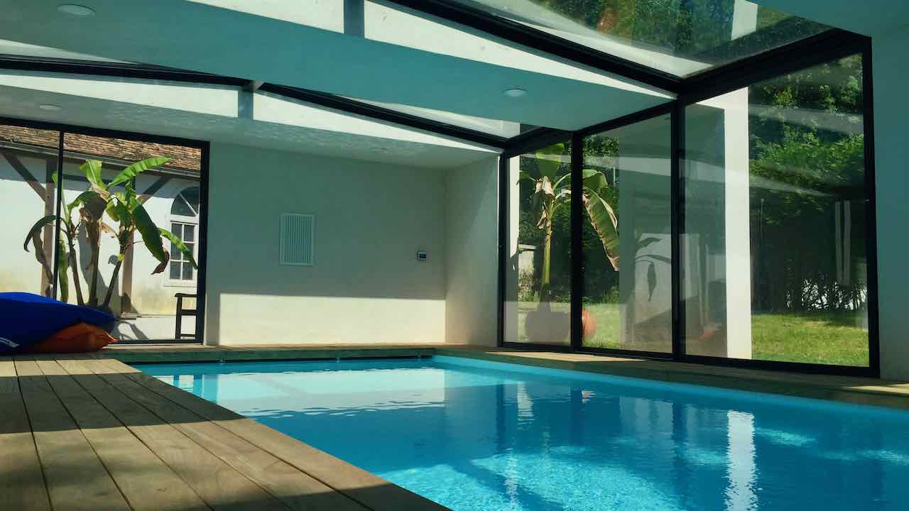 piscine intérieur avec toiture vitrée et baies oculissantes 
