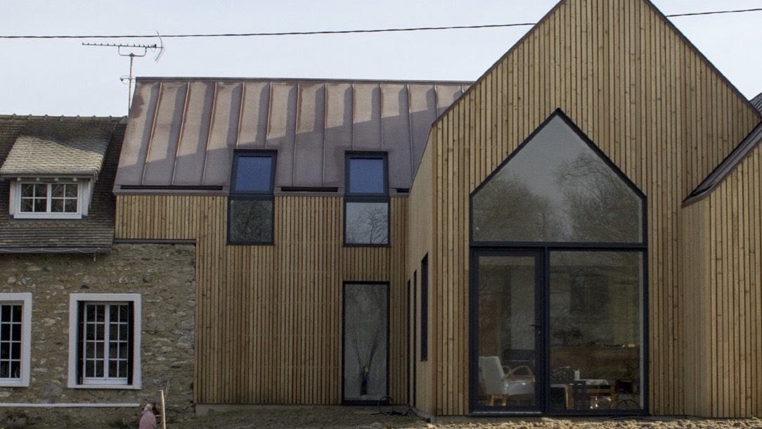 Maison façade en bois avec porte en verre et fenêtres fixes